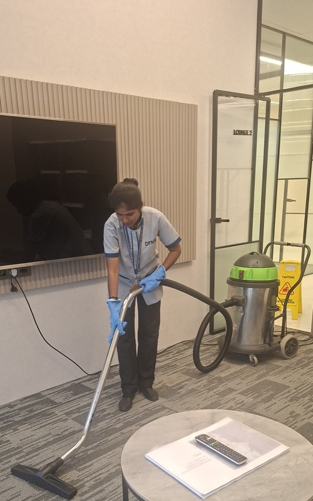 DFMS housekeeping staff vacuuming a corporate lounge